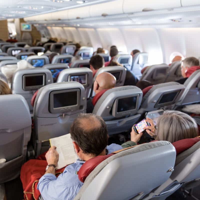 full airplane, travelers sitting on a busy plane