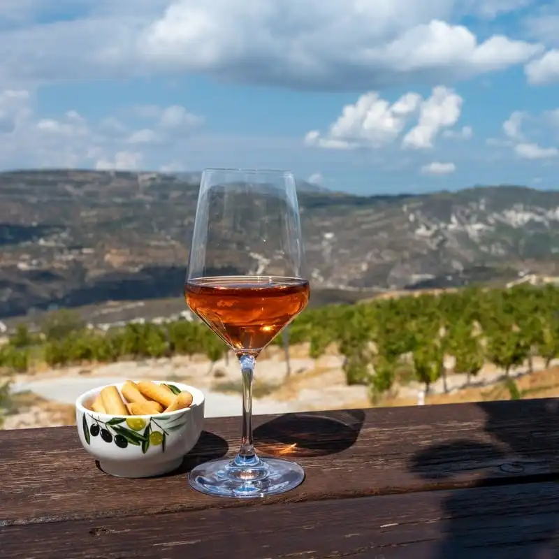 Glass Of Rose Wine Pictured Against The Backdrop Of The Troodos Mountain Range In Central Cyprus, Eastern Mediterranean